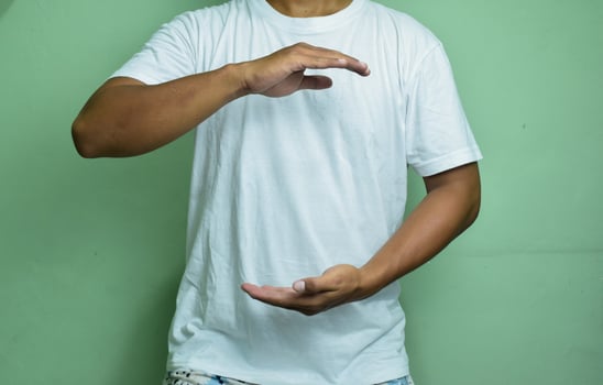 man holding hands near chest on green background photo