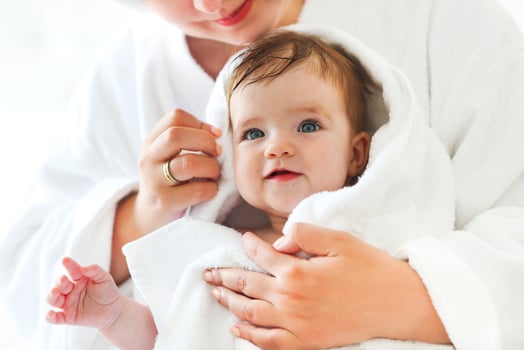 Young woman in the room with baby after bath photo
