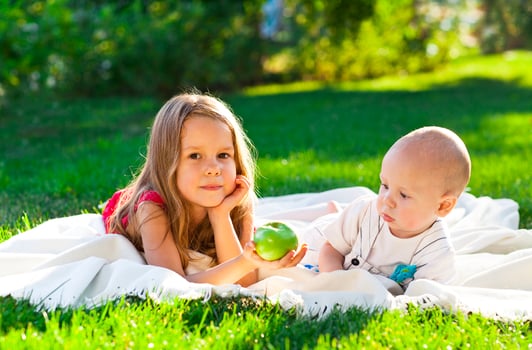 Two children baby brother and sister on green meadow photo