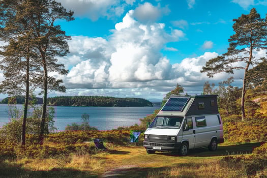 A charming campervan, equipped with solar panels, is parked in a serene lakeside location, perfectly showcasing sustainable travel while surrounded by stunning natural beauty and tranquility photo