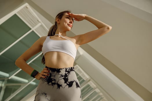 Female athlete in sportswear have a rest after morning jogging outside while looks away photo