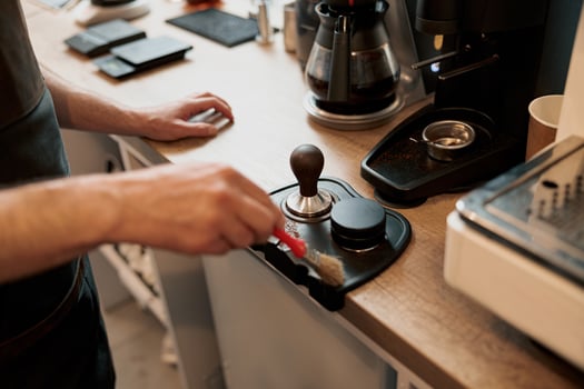 Male coffee shop owner cleaning up counter for service to customer photo