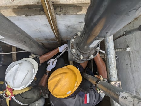 Two Workers Repairing a Large Pipe in a Pit photo
