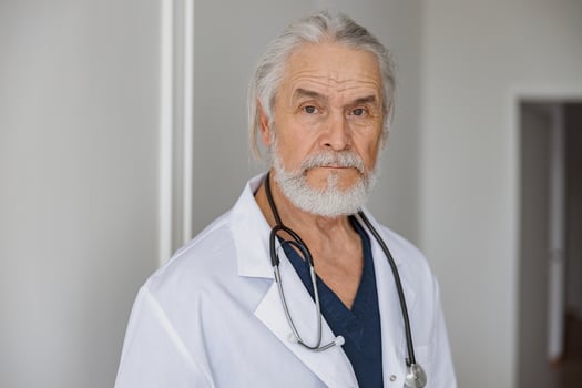 Portrait of professional doctor in uniform standing in medicine clinic hall and looking camera photo