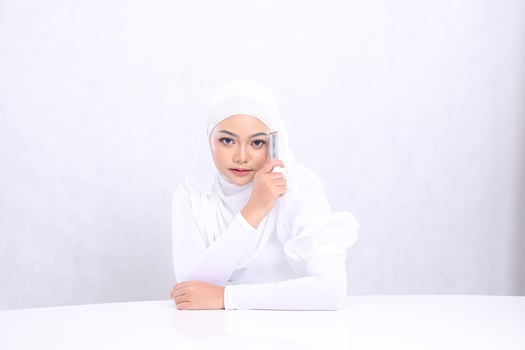 closeup lip makeup young woman indonesia hijab beautiful elegant look at camera hand hold lipstick on left face isolated white background. cosmetic advertising concept, lip color, lipstick mock up photo
