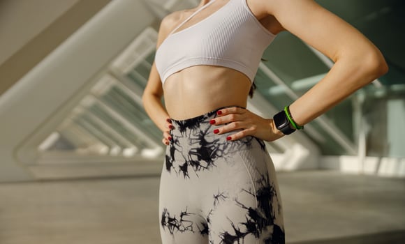 Close up of woman in sportswear have a rest after workout outside standing on building background photo
