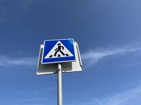 Crosswalk sign against blue sky. Bottom view. Cross road sign photo