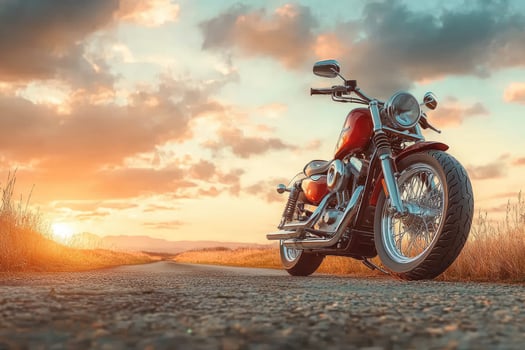 Red and chrome motorcycle standing on an empty road at sunset photo
