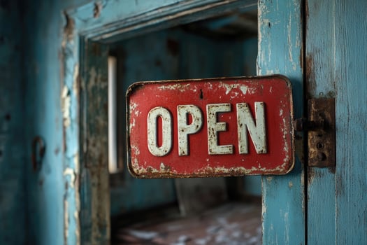 Old weathered red open sign hanging on a rusted door hinge photo