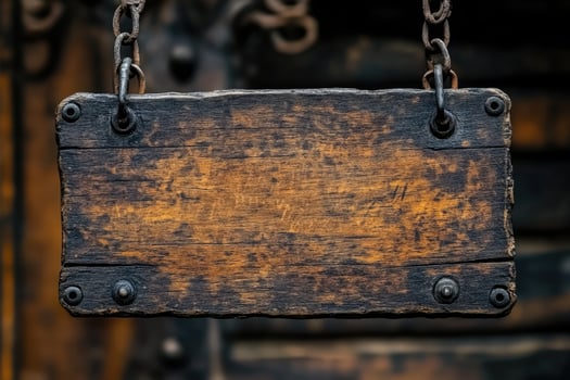 Old wooden sign hanging on rusted chains with blurred background photo