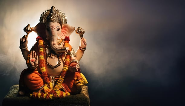 Lord Ganesha, the elephant headed god isolated on dark background photo