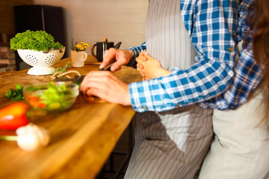 Young man and woman cooking together at kitchen photo