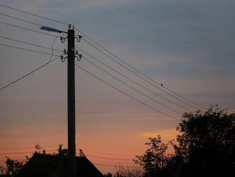 silhouette of pole and house against the background of sunrise photo