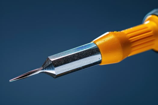 Close-up of a precision screwdriver against a blue background showcasing fine details photo