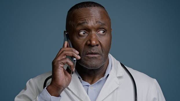 Portrait mature serious man talking on mobile phone focused puzzled confused professional doctor pediatrician therapist remotely communicates with client patient using smartphone discussing symptoms photo