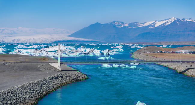 Aerial View of Glacial Lagoon with Icebergs and Snow-Capped Mountains in Iceland photo