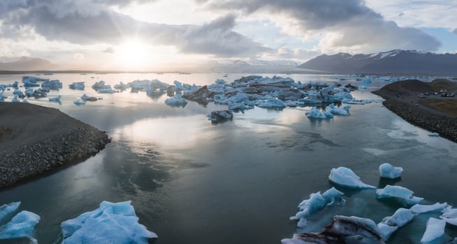 Aerial View of Glacial Lagoon with Icebergs and Snow-Capped Mountains in Iceland photo