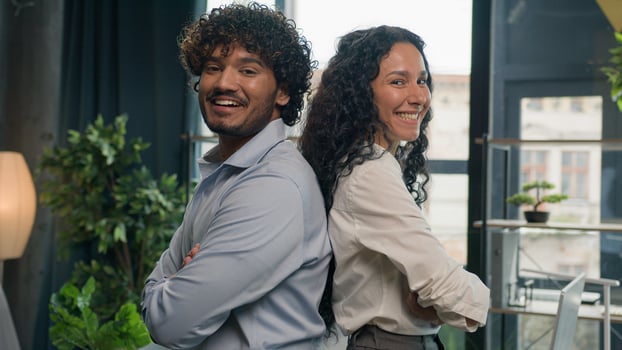 Two business partners multiracial colleagues Arabian man businessman and Hispanic woman businesswoman posing arms crossed in office diverse managers team leaders happy smiling partnership cooperation photo