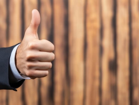 Thumbs Up Gesture in Suit with Wood Background photo