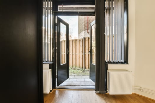 A door opens into a room with a wooden floor photo