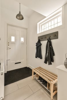 A white entryway with a coat rack and shoes photo