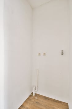 A white bathroom with a toilet and a wooden floor photo