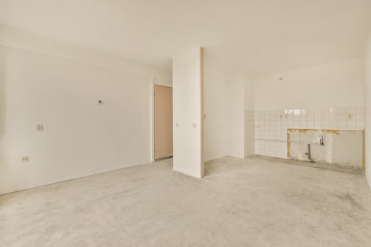 An empty room with a door and a toilet photo