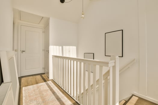A hallway with white walls and wooden floors photo