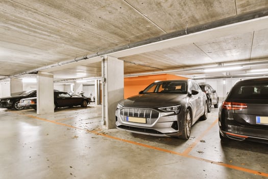 A parking garage with several cars parked inside photo
