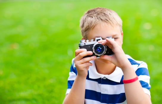 Happy smiling little boy with retro vintage camera photo