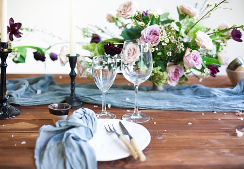 Bouquet of pink flowers on a table set for dinner with candles photo