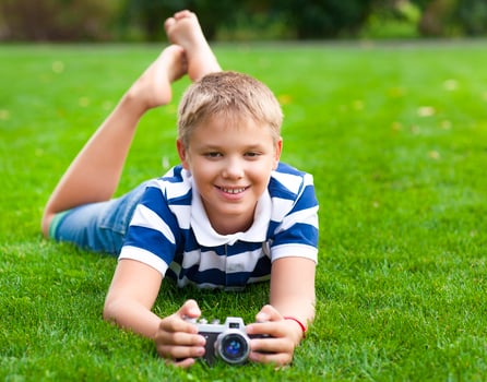 Happy smiling little boy with retro vintage camera photo