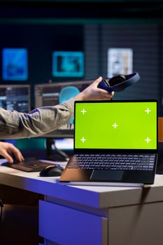 Focus on green screen laptop used by developer updating artificial intelligence machine learning algorithm. Close up shot of mockup notebook used by IT expert programming AI photo