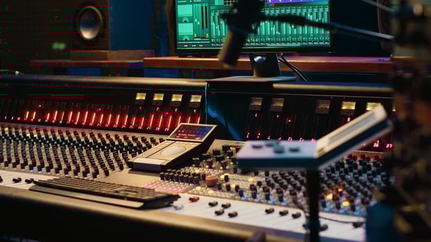 Control room with technical equipment and music recording software, professional studio editing and producing tracks. Audio console with moving faders and colored meters, high quality sounds. photo