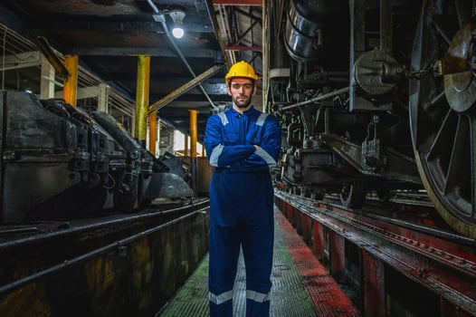 man in a blue and yellow outfit stands in a dark room photo