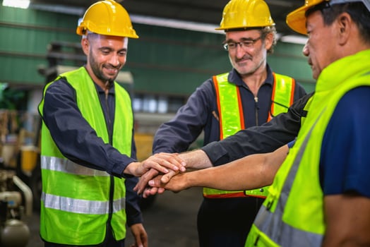 Three men in safety vests are shaking hands photo