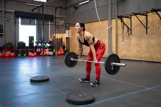 Fit mature woman dead-lifting in a cross training center photo