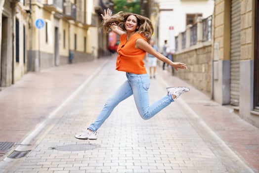 Happy woman celebrating jumping free in the street photo