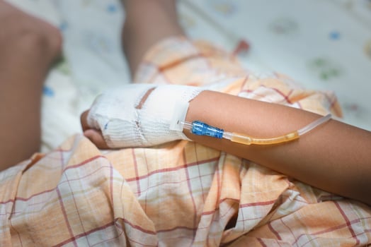 Close up child hand with tube of normal saline infusion at the hospital because it is influenza A. Hand of a patient in Hospital ward. Concept about treatment, emergency, medical, chemotherapy, sick. photo