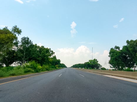 Highway road side view with green trees and blue sky photo