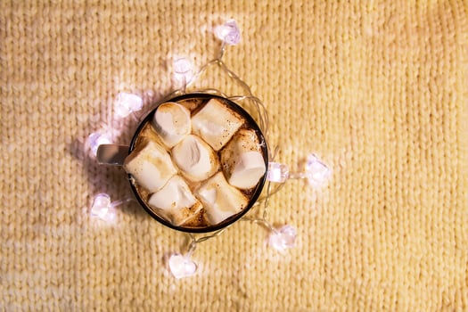 Ceramic mug with hot fresh cocoa drink with marshmallow on soft pink background. photo