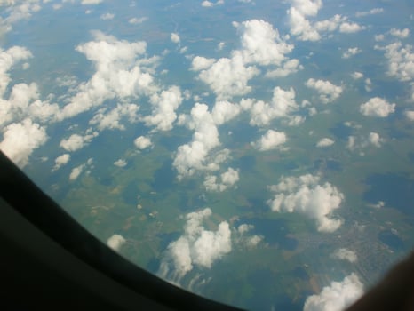 View from airplane window. White clouds above the land. photo