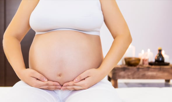 Young pregnant woman doing yoga at home photo
