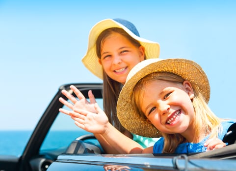 Portrait of smiling two children at beach in the car. Holiday and travel concept photo