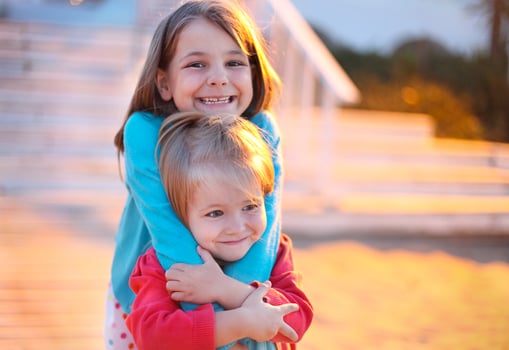 Sisters playing on the beach at the evening time photo