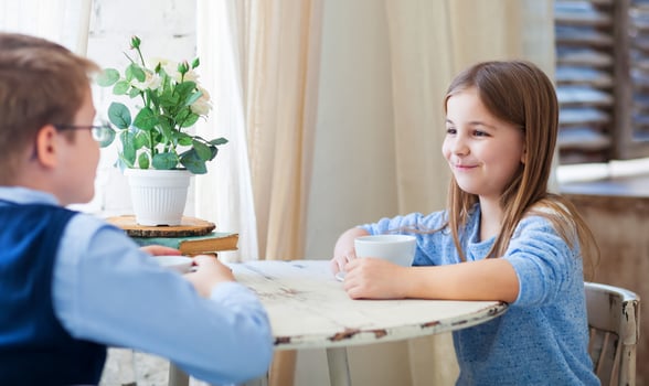 Boy and girl drinking tea and talking in cafe photo