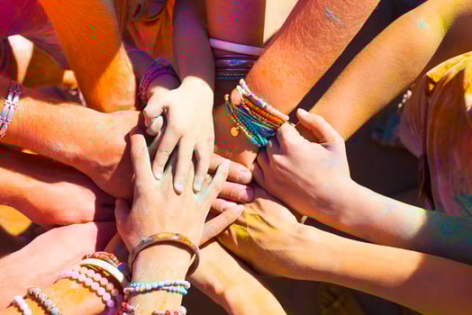 Friends putting their hands together in a sign of unity and teamwork photo