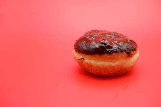 donut cake with chocolate topping on top. donut cake isolated on red background. photo
