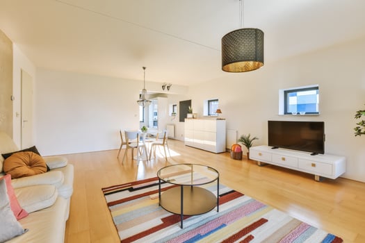 A living room with a couch, coffee table and television photo