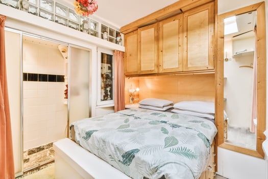 A bedroom with a bed, a shower and a cabinet photo